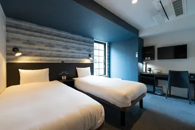 a hotel room with two beds and a desk at HOTEL TABARD TOKYO in Tokyo