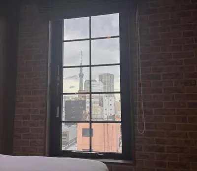 a bedroom window with a view of a city skyline at HOTEL TABARD TOKYO in Tokyo