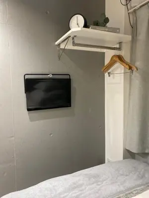 a bedroom with a tv on the wall and a bed at Itos Ebisu in Tokyo
