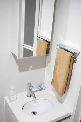 a bathroom sink with a mirror and a towel at Itos Ebisu in Tokyo
