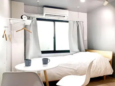 a bedroom with a bed and a table and chairs at Itos Ebisu in Tokyo