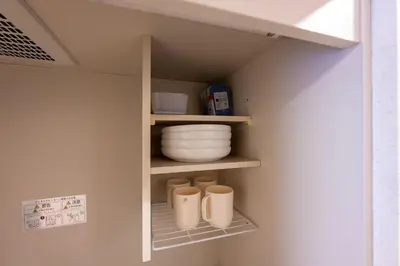 a cupboard with bowls and plates on a shelf at LUANA in BELUBEE in Tokyo