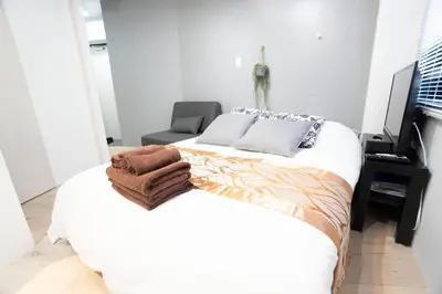 a bedroom with a bed with a towel on it at Hill Side Terrace Hiroo Shibuya 201 in Tokyo