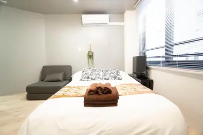 a bedroom with a bed with a towel on it at Hill Side Terrace Hiroo Shibuya 201 in Tokyo