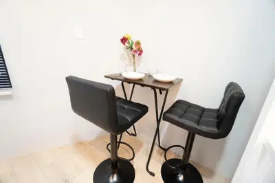 a small table with two chairs and a table with flowers at Hill Side Terrace Hiroo Shibuya 201 in Tokyo