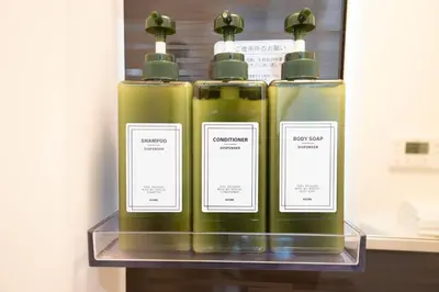 three green bottles on a shelf with labels on them at Hill Side Terrace Hiroo Shibuya 201 in Tokyo