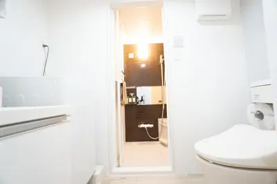 a bathroom with a toilet and a door to a shower at Hill Side Terrace Hiroo Shibuya 202 in Tokyo