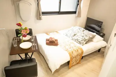 a small room with a bed and a table at Hill Side Terrace Hiroo Shibuya 202 in Tokyo