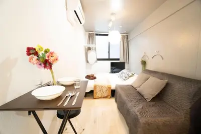 a living room with a couch and a table with flowers at Hill Side Terrace Hiroo Shibuya 203 in Tokyo
