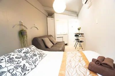a bedroom with a bed and a couch in it at Hill Side Terrace Hiroo Shibuya 203 in Tokyo