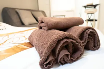 a pile of brown towels sitting on a bed at Hill Side Terrace Hiroo Shibuya 203 in Tokyo