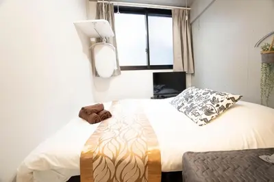 a bedroom with two beds and a window at Hill Side Terrace Hiroo Shibuya 103 in Tokyo