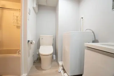 a white bathroom with a toilet and a sink at Hill Side Terrace Hiroo Shibuya 103 in Tokyo