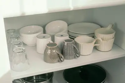 a shelf filled with plates and cups and dishes at 7 Rooms Hotel & Cafe - Boutique Designer Hotel - 30 mins from Disneyland&Tokyo in Tokyo