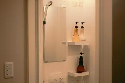 a bathroom with a mirror and bottles on the wall at 7 Rooms Hotel & Cafe - Boutique Designer Hotel - 30 mins from Disneyland&Tokyo in Tokyo
