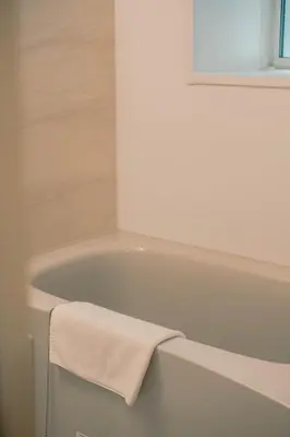 a bathroom with a bath tub with a towel on it at 7 Rooms Hotel & Cafe - Boutique Designer Hotel - 30 mins from Disneyland&Tokyo in Tokyo