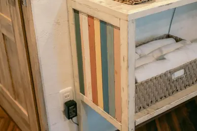 a wooden cabinet with a glass door with towels in it at 7 Rooms Hotel & Cafe - Boutique Designer Hotel - 30 mins from Disneyland&Tokyo in Tokyo