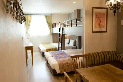 a hotel room with two bunk beds and a table at 7 Rooms Hotel & Cafe - Boutique Designer Hotel - 30 mins from Disneyland&Tokyo in Tokyo