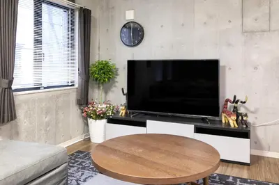 a living room with a large television and a table at Uhome Otsuka Villa in Tokyo