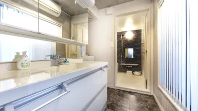 a white bathroom with a sink and a shower at Uhome Otsuka Villa in Tokyo
