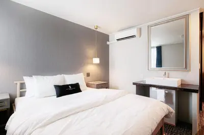 a bedroom with a large white bed and a sink at The Barn Tokyo in Tokyo
