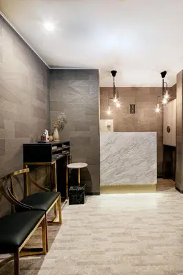 a lobby with a stone wall and a table and chairs at The Barn Tokyo in Tokyo