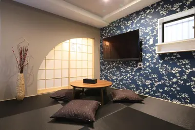 a room with a table and a tv on a wall at Hikari House in Tokyo