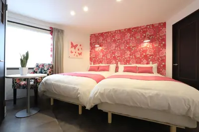 a bedroom with a large bed with a red headboard at Hikari House in Tokyo