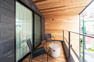 a balcony with black chairs and a wooden wall at ENGAWA & GIVE Nakano in Tokyo