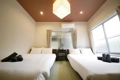 two beds in a room with two windows at Villa Belle-Vue Kanegafuchi in Tokyo