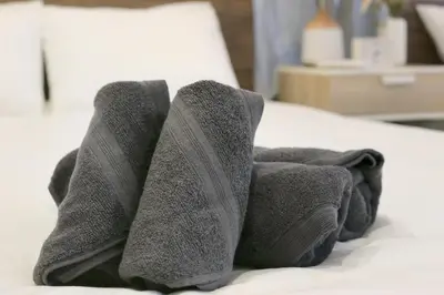 a pile of towels sitting on top of a bed at Villa Belle-Vue Kanegafuchi in Tokyo