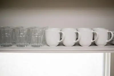 a row of cups and glasses sitting on a shelf at Villa Belle-Vue Kanegafuchi in Tokyo