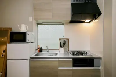 a small kitchen with a sink and a microwave at Villa Belle-Vue Kanegafuchi in Tokyo