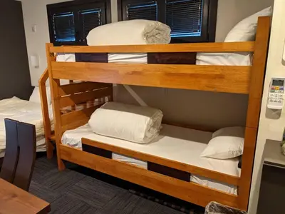 a room with two bunk beds with white pillows at Gennoya in Tokyo
