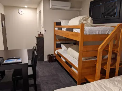 a room with two bunk beds with a desk and a desk at Gennoya in Tokyo