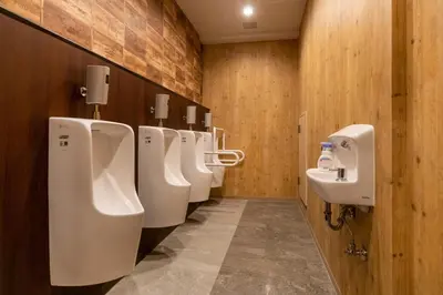 a bathroom with a row of urinals and sinks at eeGee STAY Kamata in Tokyo