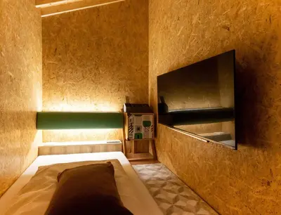 a small room with a bed and a television at eeGee STAY Kamata in Tokyo