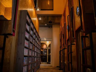 a hallway of a library with books on the walls at eeGee STAY Kamata in Tokyo