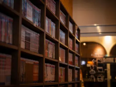 a library with many shelves filled with books at eeGee STAY Kamata in Tokyo