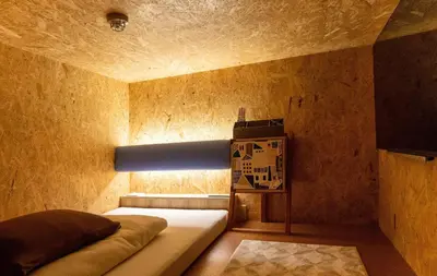 a bedroom with a bed with a light on the wall at eeGee STAY Kamata in Tokyo