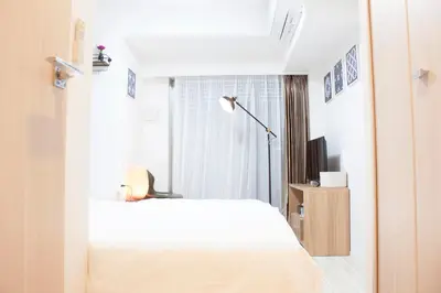 a bedroom with a white bed and a window at Hotel Shu in Tokyo