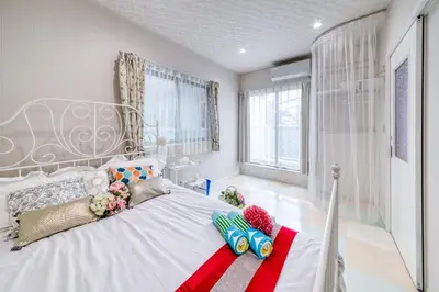 a bedroom with a white bed with a large window at Diamond Moon Palace Takadanobaba,2 stops to Shinjuku in Tokyo