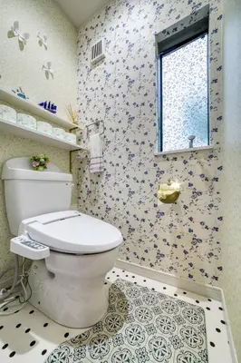a bathroom with a toilet and floral wallpaper at Diamond Moon Palace Takadanobaba,2 stops to Shinjuku in Tokyo