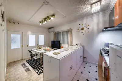 a kitchen with a white counter and a table at Diamond Moon Palace Takadanobaba,2 stops to Shinjuku in Tokyo
