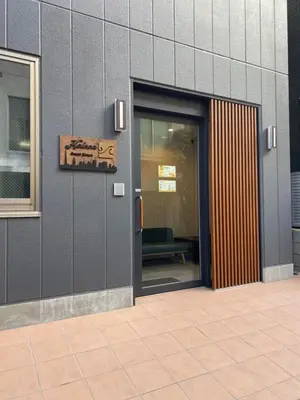 a door to a building with a sign on it at Kainoa Guesthouse in Tokyo