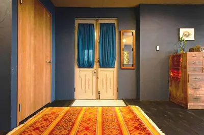 a room with a door with blue curtains and a rug at Indigo flat in Asakusa in Tokyo