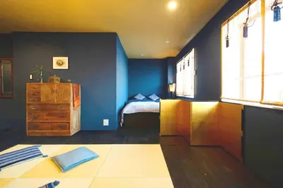 a bedroom with blue walls and a bed and a dresser at Indigo flat in Asakusa in Tokyo