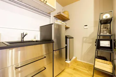 a kitchen with a stainless steel refrigerator and a sink at NEGAU House in Tokyo