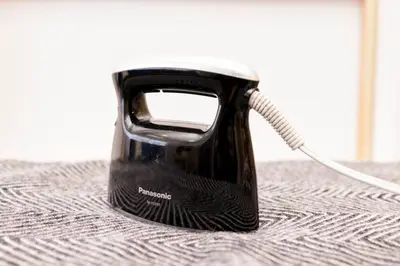 a black appliance sitting on top of a bed at NEGAU House in Tokyo
