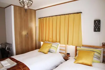two beds sitting next to each other in a bedroom at HAMA HILLS Shinjuku in Tokyo